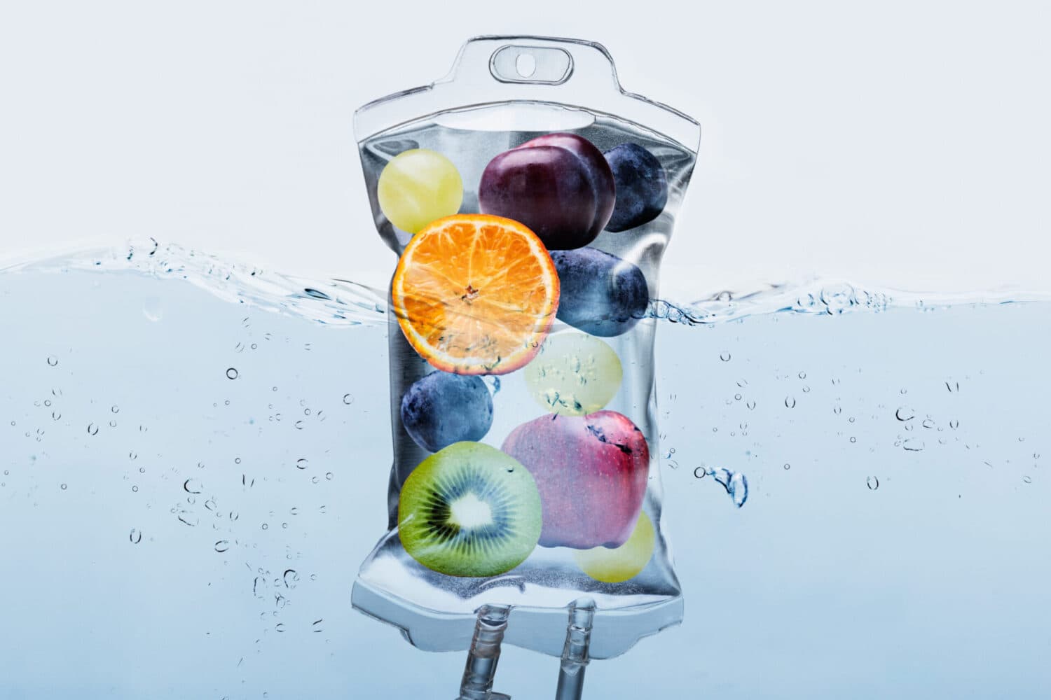 IV therapy concept — nutrient-rich infusion with fresh fruit in a clinical bag over water